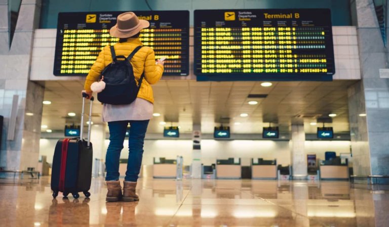 woman standing in front of flight departure board at Barcelona airport