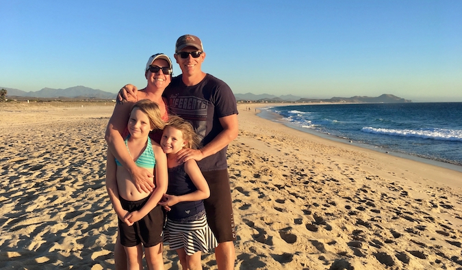 Amanda and her traveling family posing on the beach