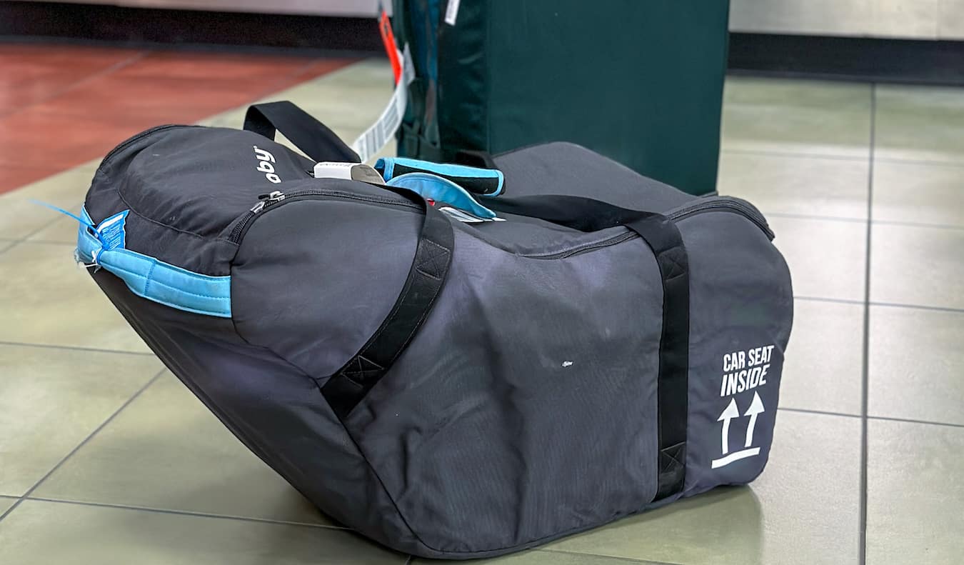 A car seat for a traveling baby ready to be checked for a long flight