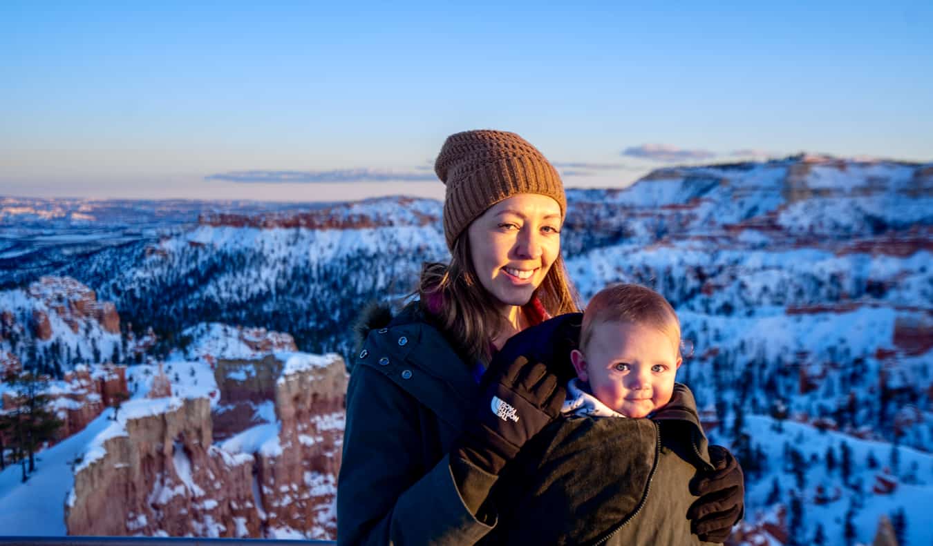 A baby in a carrier out for a hike while traveling