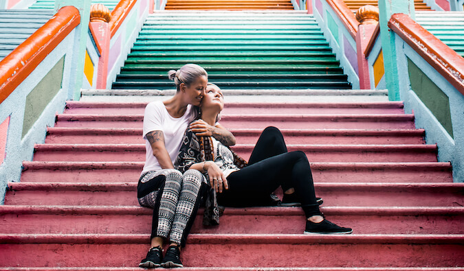 Two lesbian tarvel bloggers posing a a colorful set of stairs in Asia