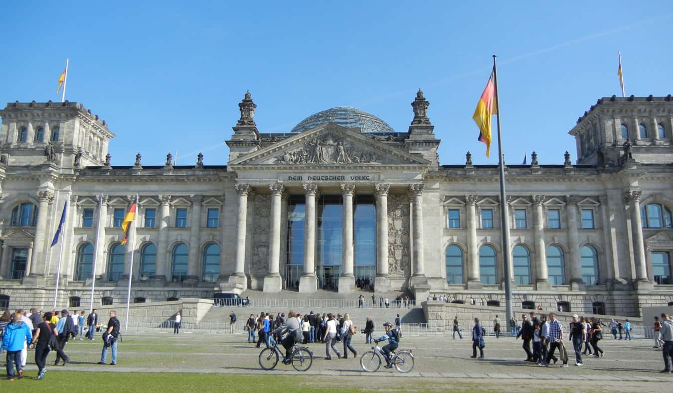 The stately Reichstag Building with the German flag flying in front, in Berlin, Germany