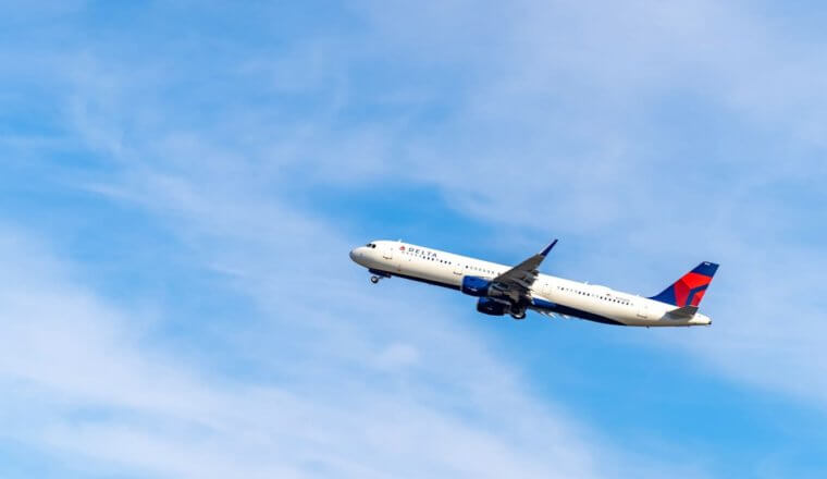 A Delta airplane climbing intoa bright blue sky after takeoff in the USA