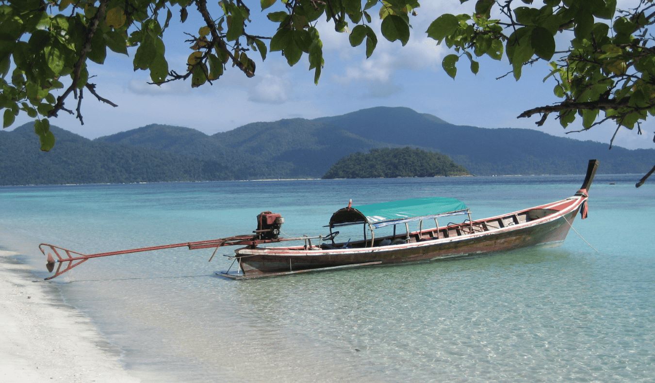 A longtail boat docked on a beach on the island of Ko Lipe, Thailand