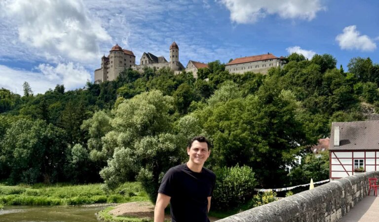 Nomadic Matt posing in front of an old castle in the Black Forest, Germany