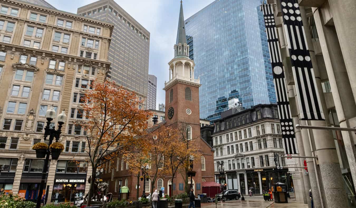 Towering buildings around a historic church in the bustling core of downtown Boston