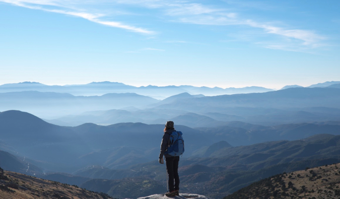 A solo female traveler standing on a mountain