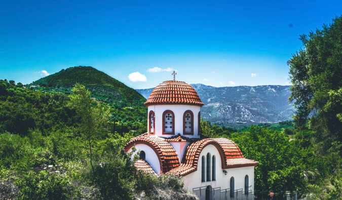 a small old building surrounded by trees in Greece