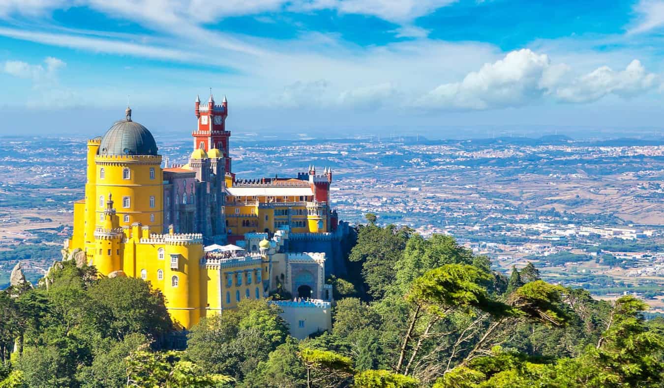 A colorful, historic building in the rugged, lush hills of Portugal