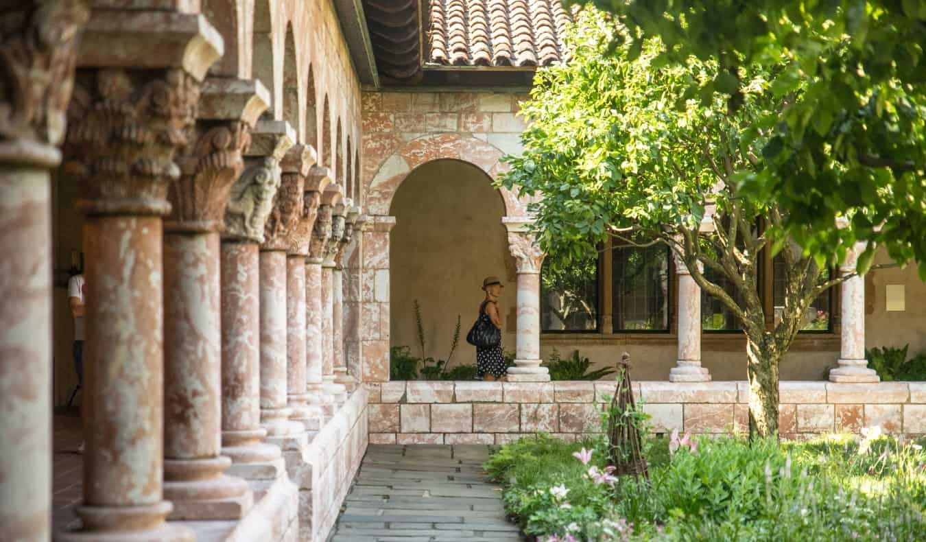 A grassy courtyard surrounded by columns at the Met Cloisters in New York City, USA