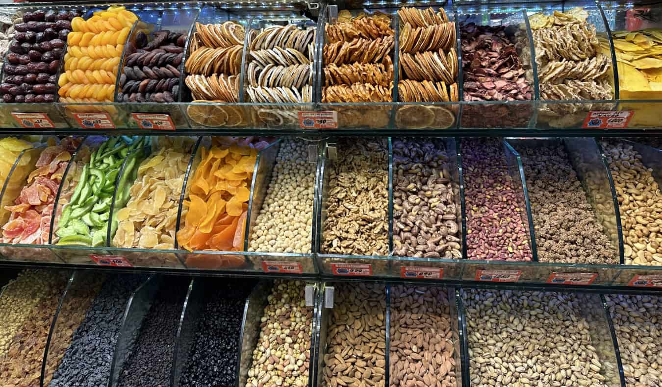 bulk bins in a market filled with nuts, dried fruits, and other snacks