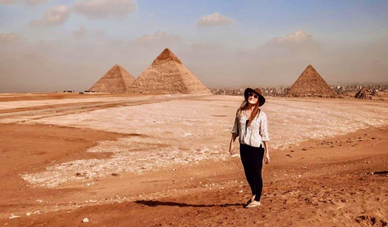 Monica, a solo female traveler, posing near the pyramids in Egypt