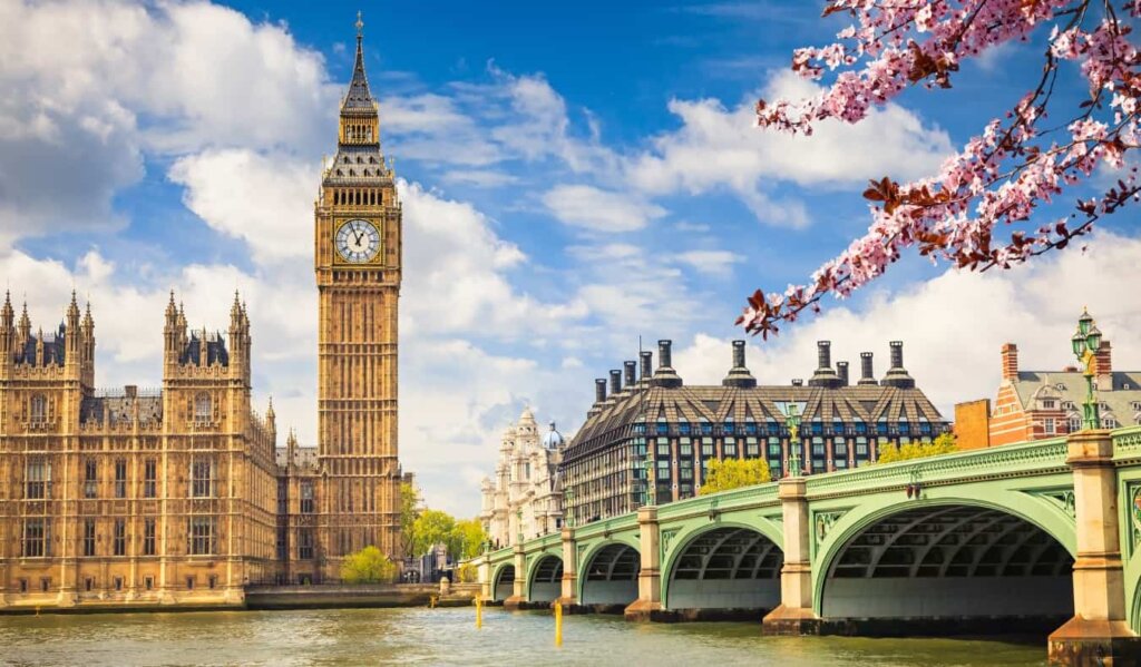 View of Big Ben and Parliament across the river Thames with cherry blossoms in bloom in London, England