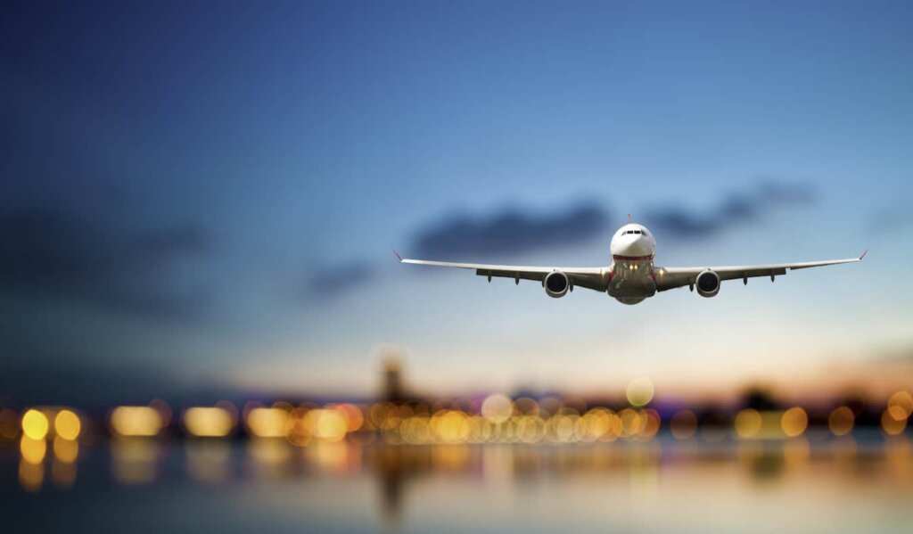 A huge commercial airline coming in to land against a bright blue sky