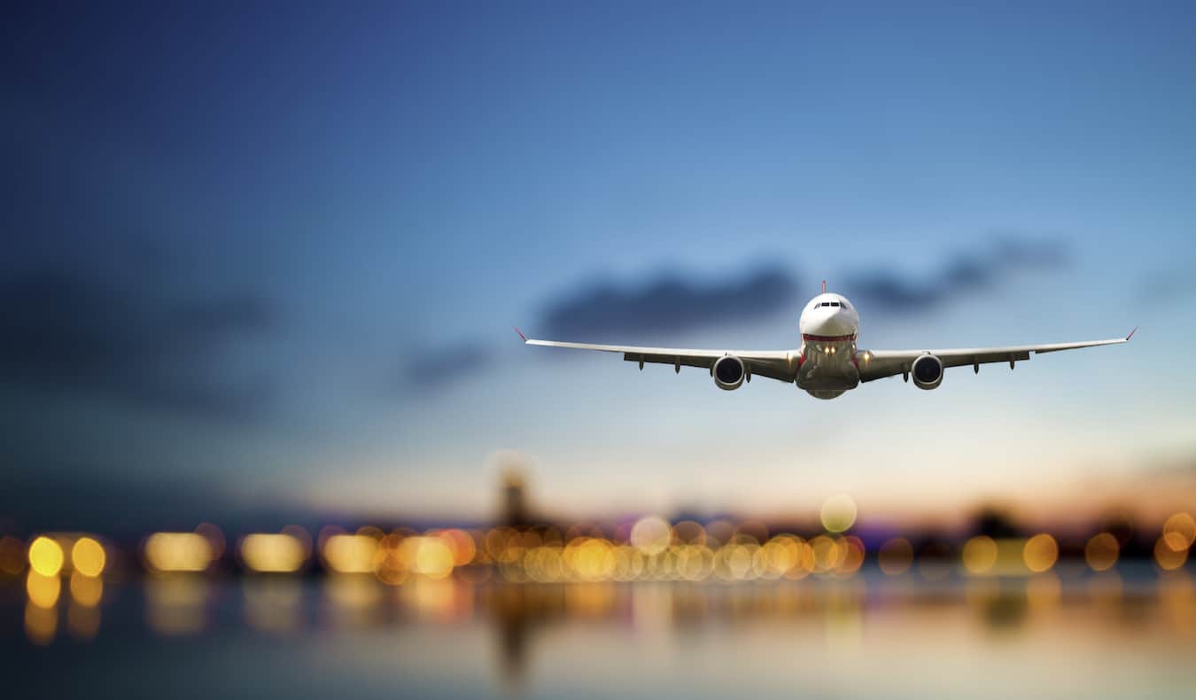 A huge commercial airline coming in to land against a bright blue sky