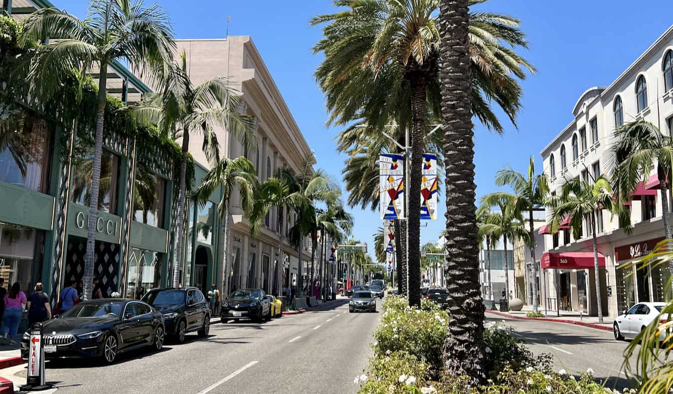 A wide street lined by shops in sunny Los Angeles, California