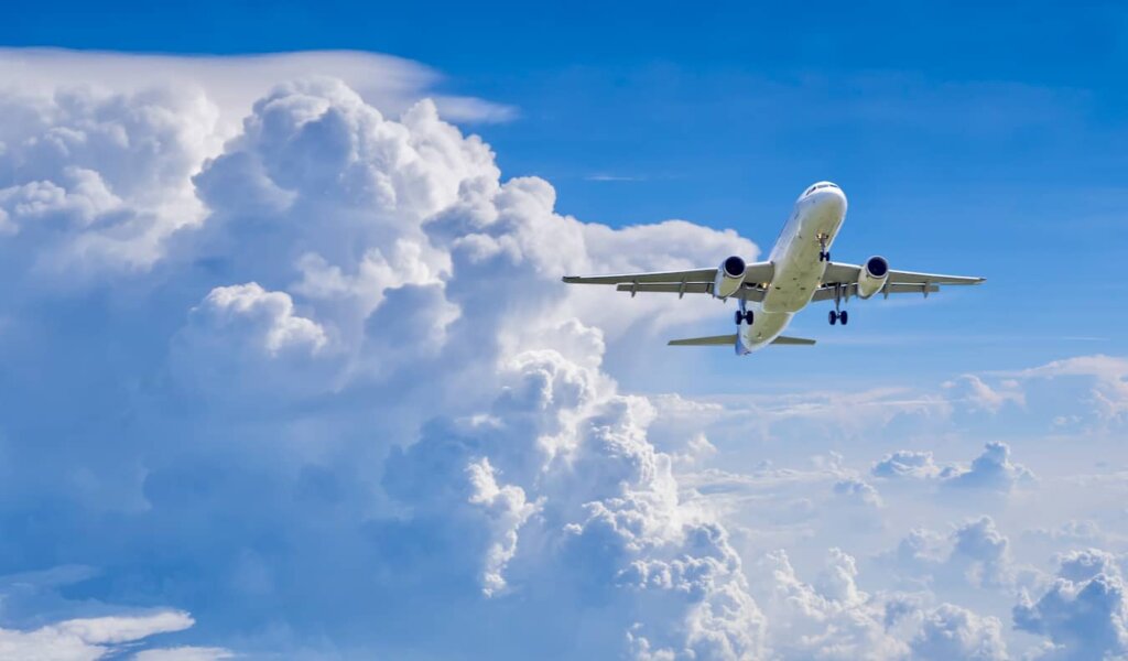 A commercial airplane flying in the bright blue sky