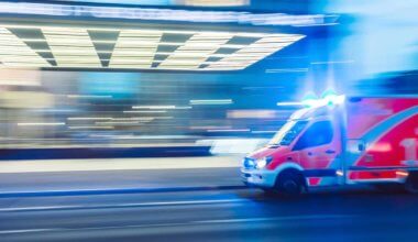 An ambulance driving quickly at night with flashing lights