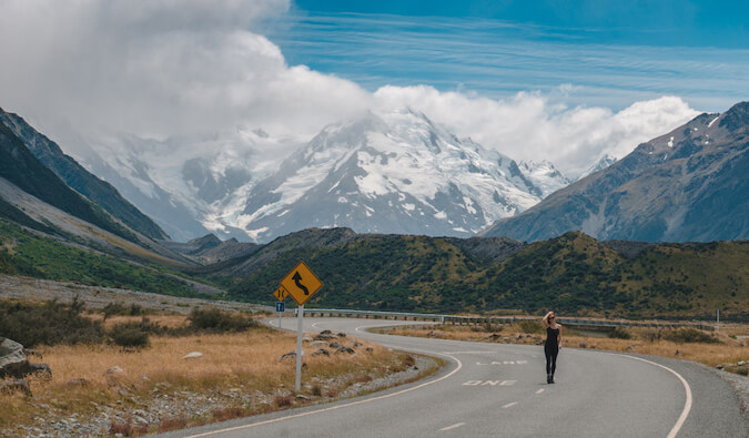 Kristin Addis standing on a empty winding road in the mountains