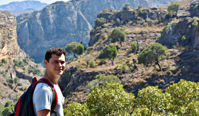 Nomadic Mattin Africa facing camera on left side in the background are mountains with trees