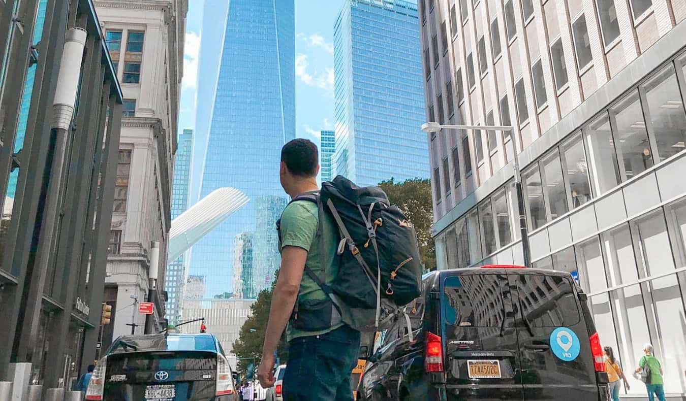 Nomadic Matt with his backpack on standing in a busy NYC street