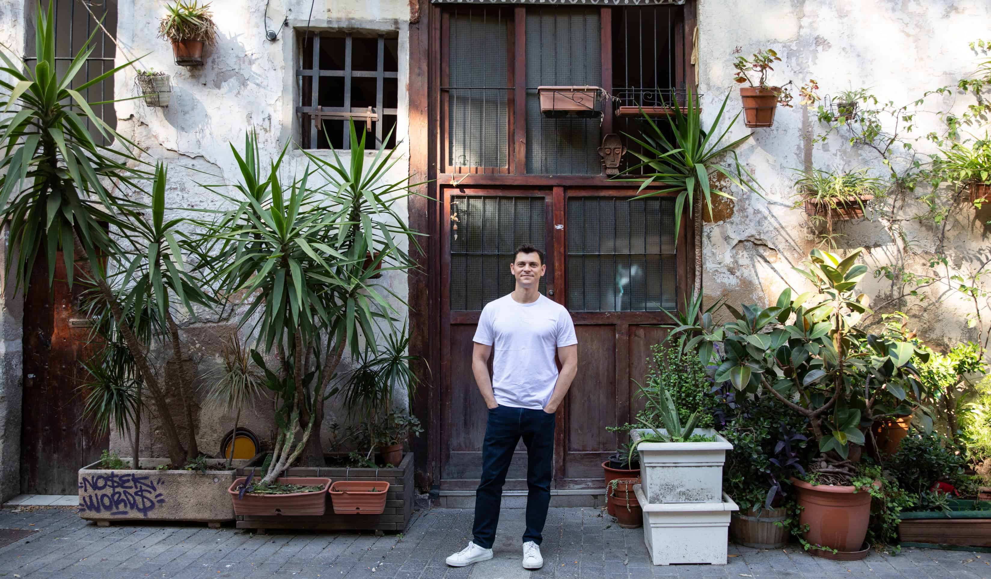 Nomadic Matt standing in front of a wall covered in hanging plants in Barcelona, Spain