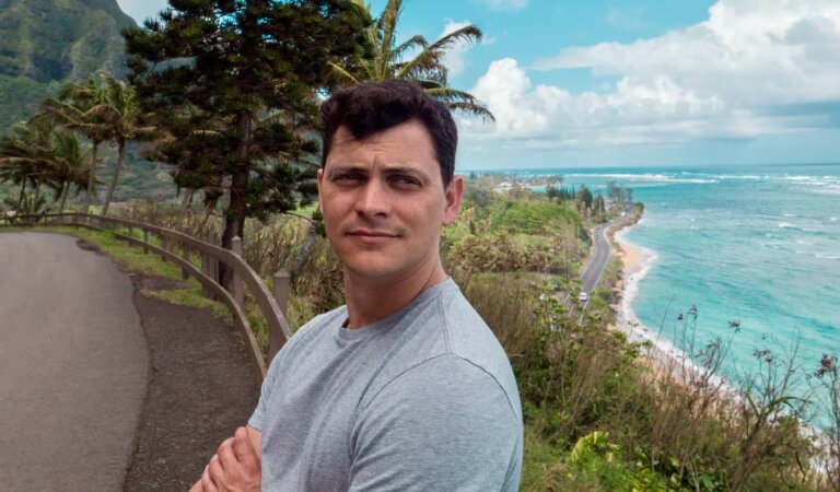 Nomadic Matt posing for a photo along the winding road of Hawaii