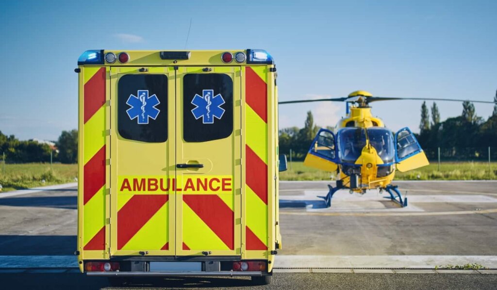 An ambulance parked next to a helicopter on a medical evacuation