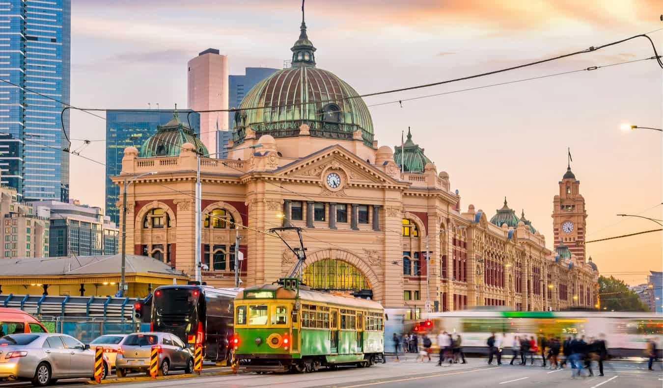 The busy downtown of Melbourne, Australia with streetcars and people crossing the road