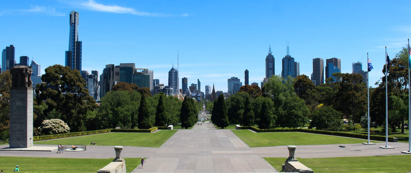 A greeny park in Melbourne, Australia with the cityscape in the distant background on a sunny day