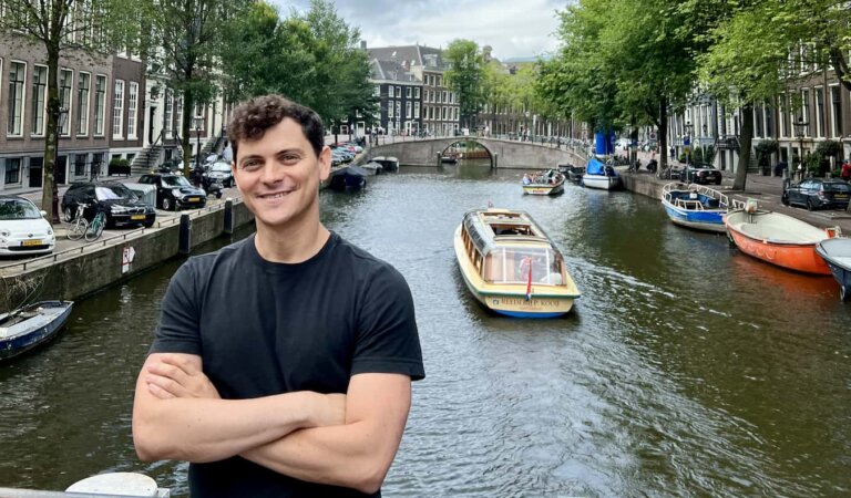 Nomadic Matt posing near the canal in Amsterdam