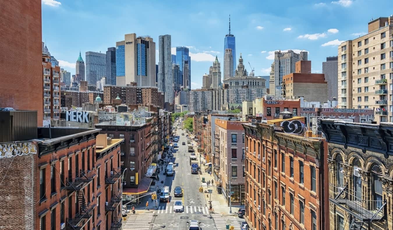 New York City viewed from the Manhattan bridge, with tenement buildings in the foreground and modern skyscrapers in the background