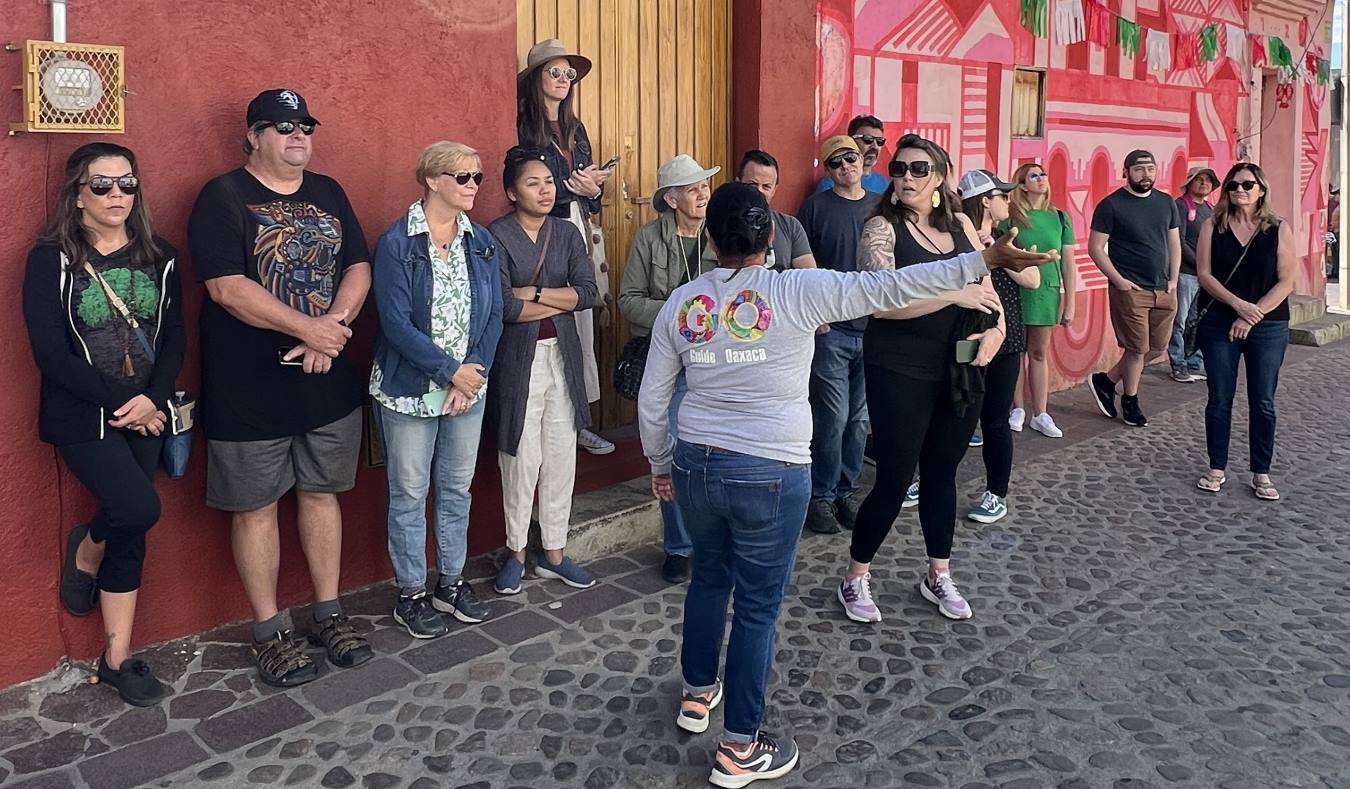 A tour guide talking to a group of people on a walking tour in Oaxaca, Mexico