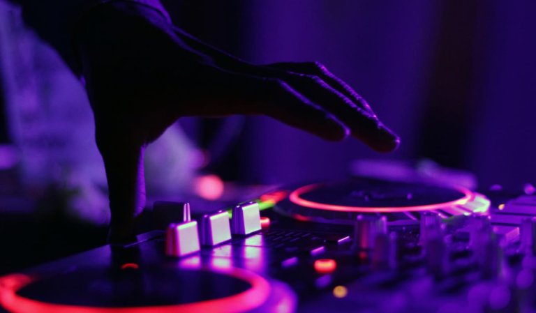 A turntable at a rave with purple lights