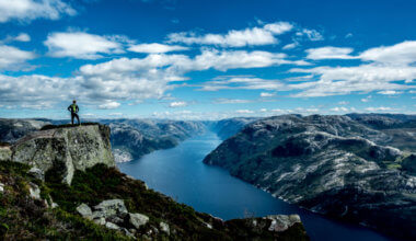 An adventurous traveler standing on a cliff looking over the landscape