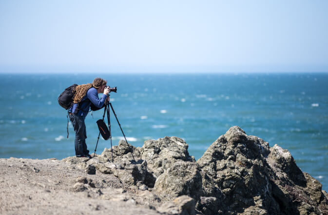 Laurence Norah taking a photo near the ocean