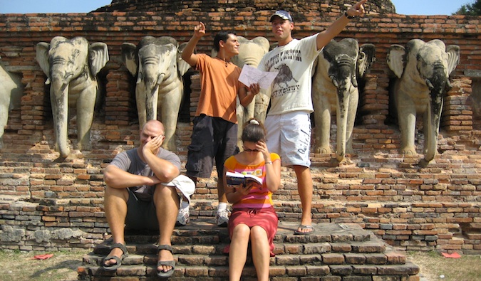 Nomadic Matt pretending to be lost with a group of backpacker friends in Asia