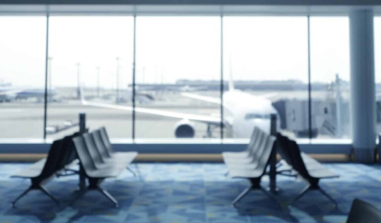 An empty airport area with an airplane boarding in the distance