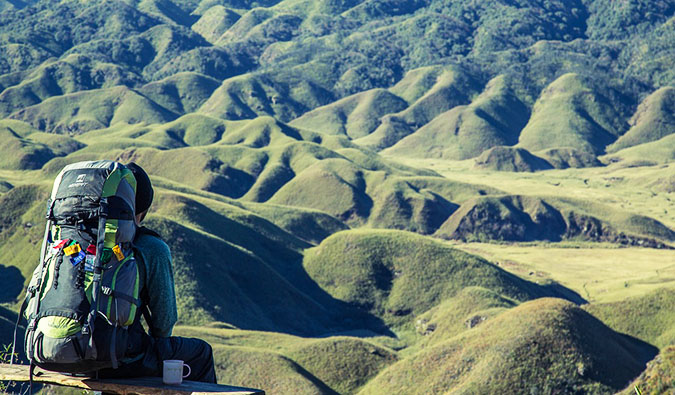 A lone hiker sitting on a ridge enjoying the beautiful view over the landscape before him