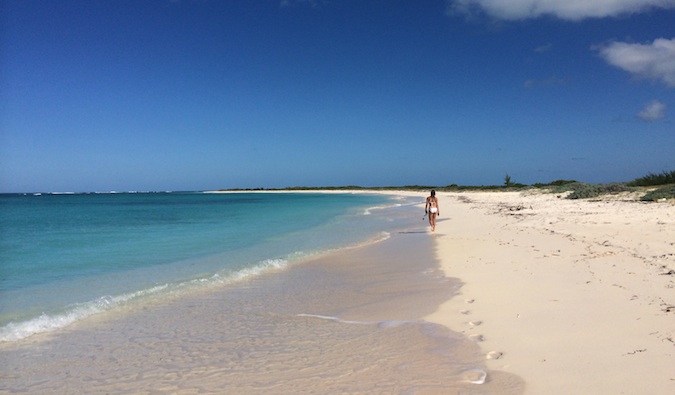 A traveler walking down a beach in the beautiful BVIs