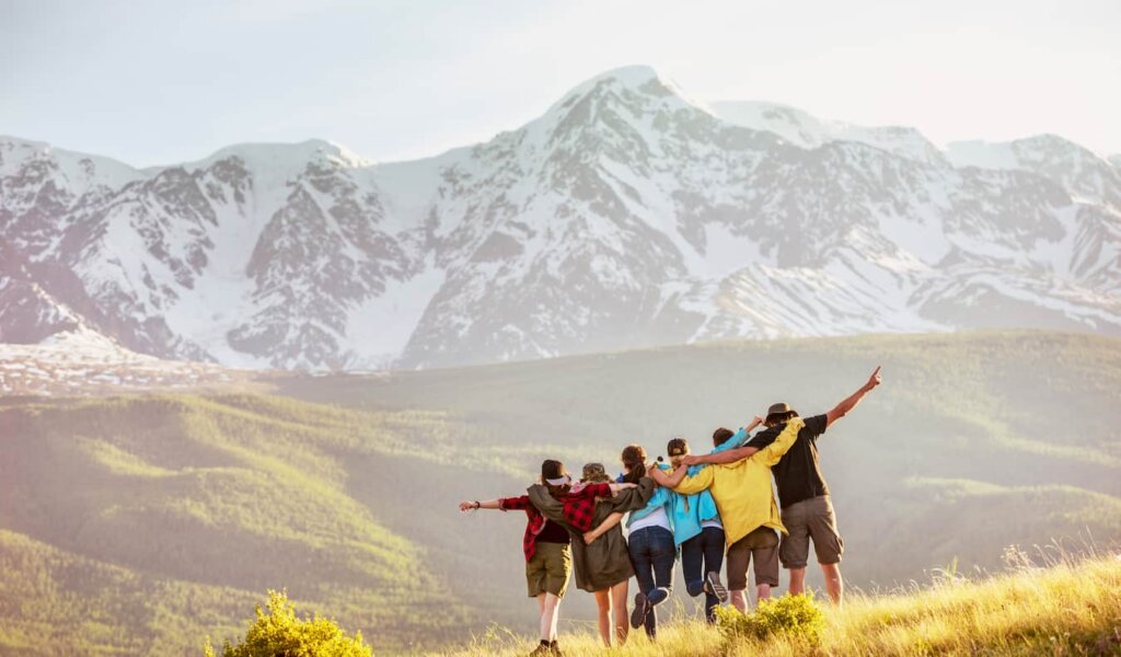 A group of travelers together hiking in the mountains in a rugged area posing for a photo